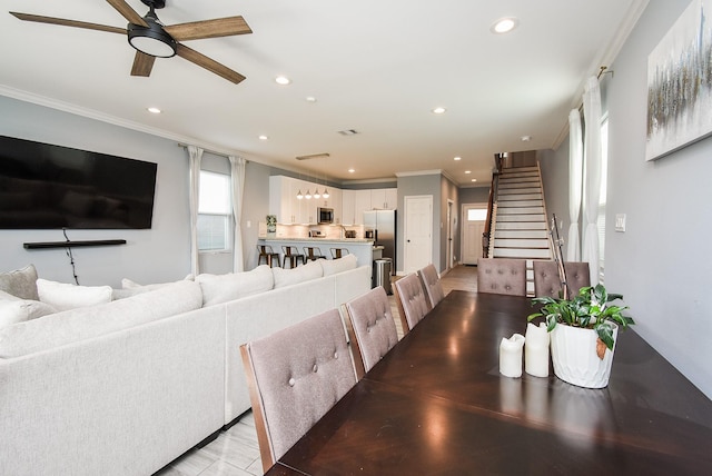 dining space with recessed lighting, ornamental molding, ceiling fan, and stairs