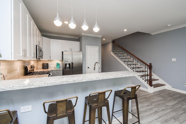 kitchen featuring stainless steel appliances, backsplash, a sink, a peninsula, and crown molding