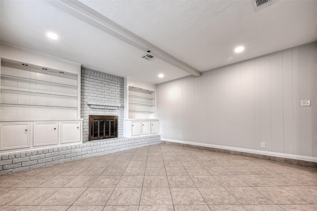 unfurnished living room with light tile patterned floors, visible vents, built in features, a fireplace, and beam ceiling