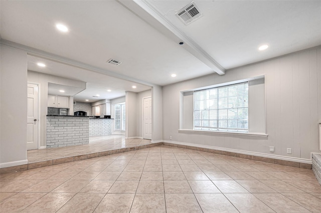 unfurnished room featuring visible vents, beamed ceiling, and light tile patterned flooring