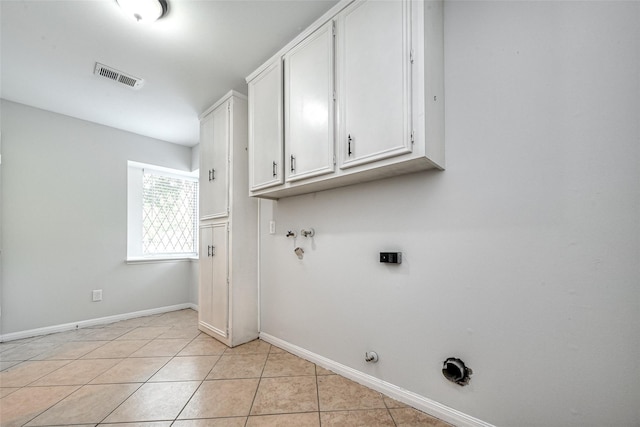 laundry area featuring light tile patterned floors, hookup for a gas dryer, cabinet space, visible vents, and baseboards