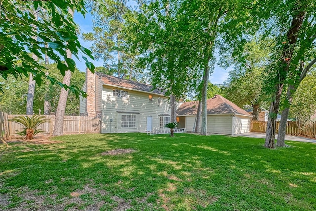 view of front of home with a fenced backyard, a front lawn, and an outbuilding
