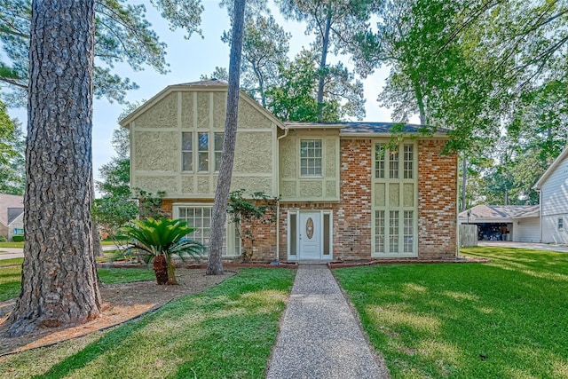 english style home featuring a front lawn and stucco siding