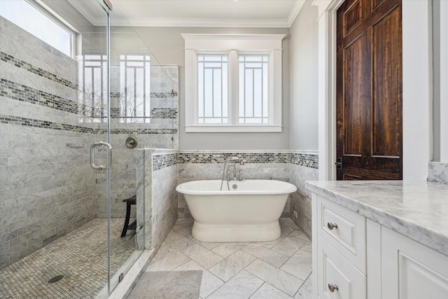 bathroom with a freestanding bath, ornamental molding, a stall shower, and vanity