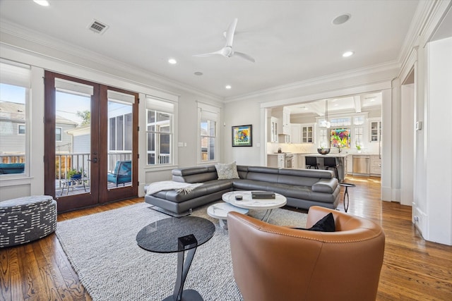 living room with ornamental molding, french doors, visible vents, and wood finished floors