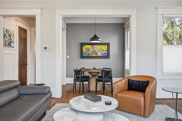 living room with ornamental molding, baseboards, and wood finished floors