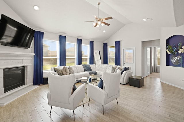 living room featuring light wood-type flooring, a glass covered fireplace, vaulted ceiling, and recessed lighting