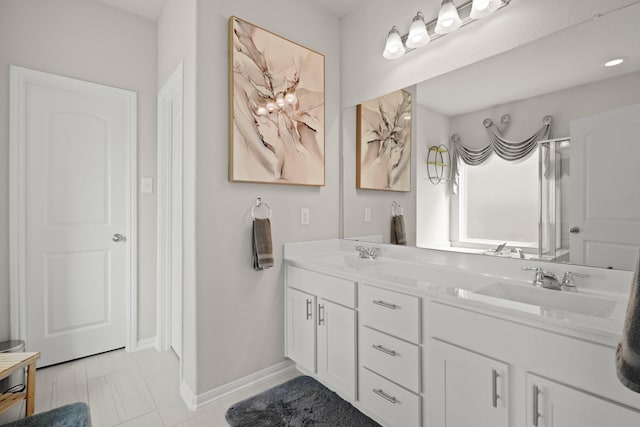 full bathroom featuring double vanity, a sink, and baseboards