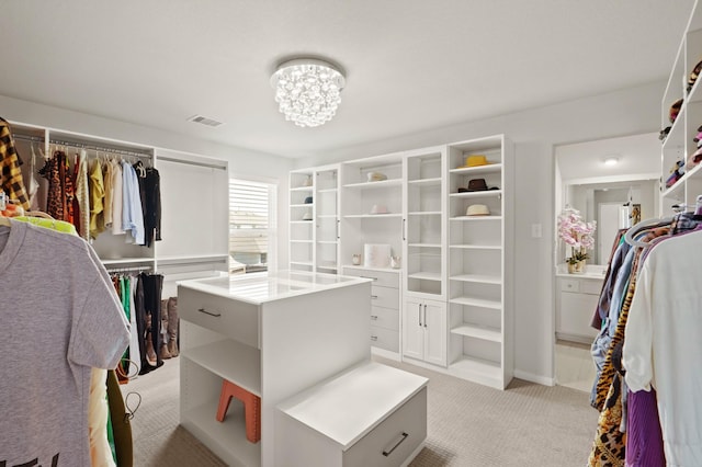 spacious closet with light carpet, an inviting chandelier, and visible vents