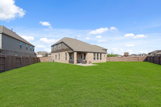 back of house featuring a patio area, a fenced backyard, brick siding, and a yard