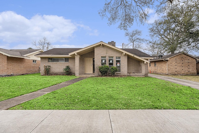 mid-century home with a chimney, a front lawn, and brick siding