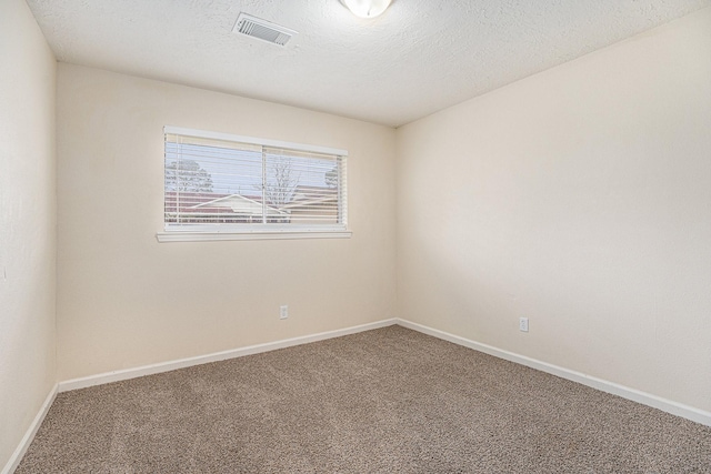 unfurnished room featuring carpet floors, baseboards, visible vents, and a textured ceiling