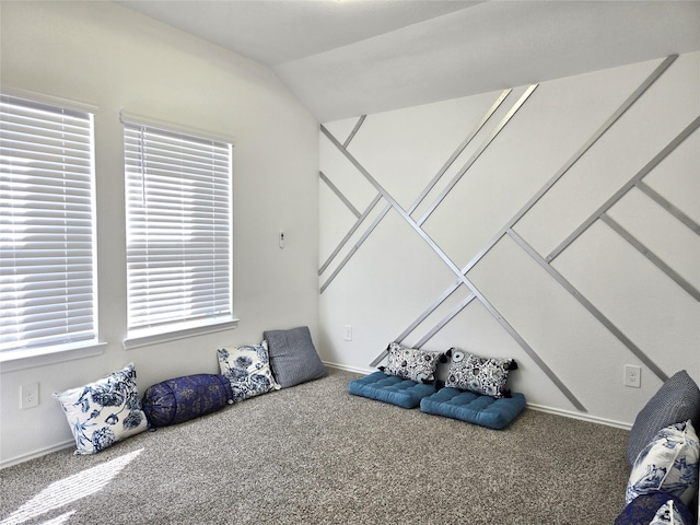 interior space with baseboards, vaulted ceiling, and carpet