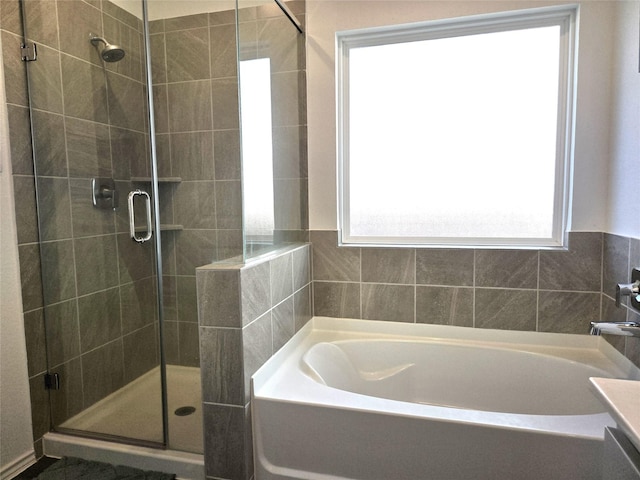 full bathroom featuring a stall shower and a bath