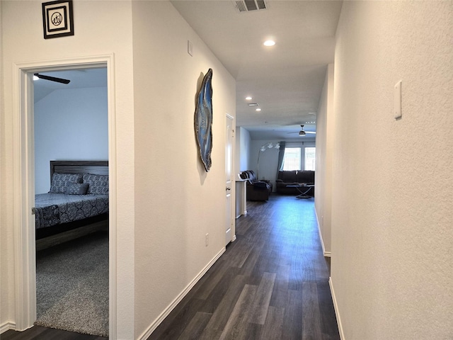 hallway with visible vents, baseboards, dark wood-type flooring, and recessed lighting