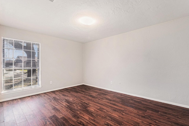 unfurnished room with dark wood-style floors, baseboards, and a textured ceiling