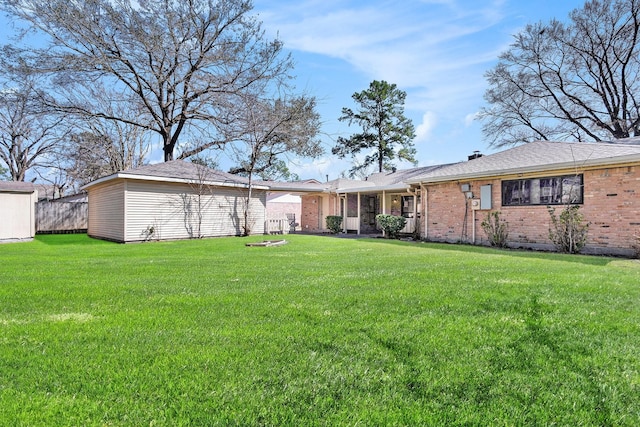 rear view of house with a lawn and brick siding