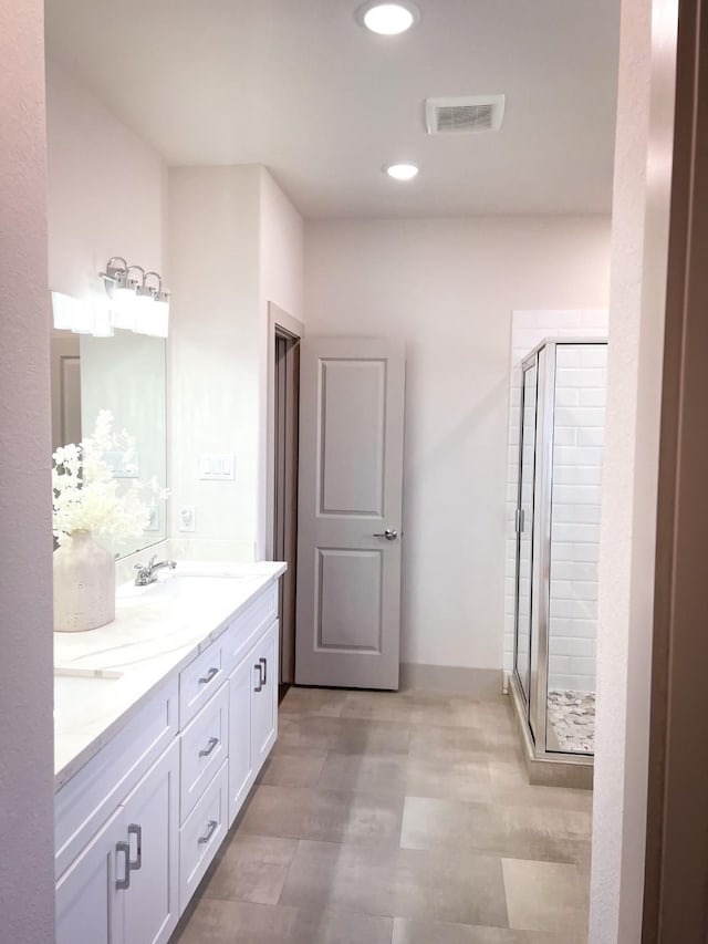 full bath with recessed lighting, a sink, visible vents, a shower stall, and double vanity