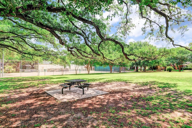 view of property's community featuring a lawn and fence