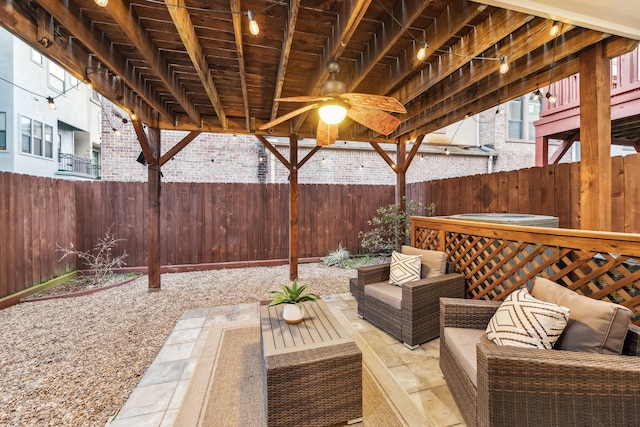 view of patio / terrace featuring an outdoor living space, a fenced backyard, ceiling fan, and a hot tub