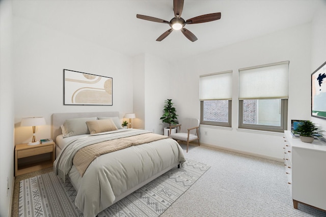 bedroom with ceiling fan, light colored carpet, and baseboards