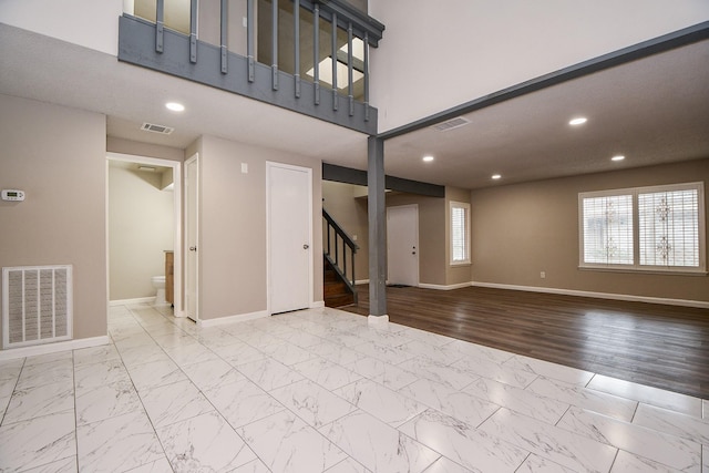 interior space with marble finish floor, visible vents, baseboards, and stairs