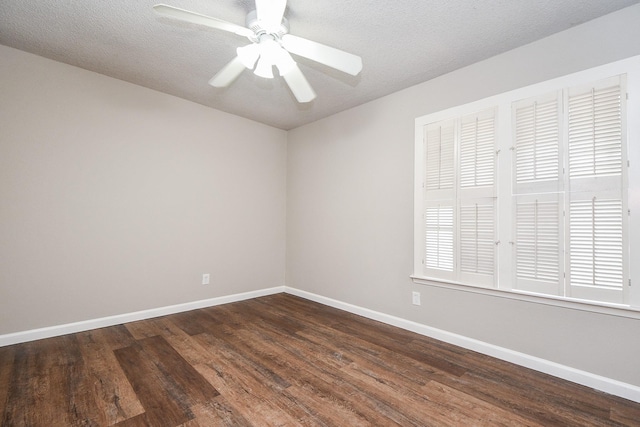 unfurnished room with ceiling fan, a textured ceiling, dark wood finished floors, and baseboards