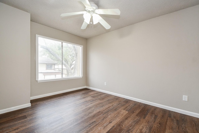 unfurnished room with a textured ceiling, ceiling fan, dark wood finished floors, and baseboards