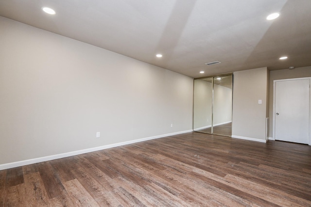 spare room featuring dark wood-style floors, recessed lighting, visible vents, and baseboards