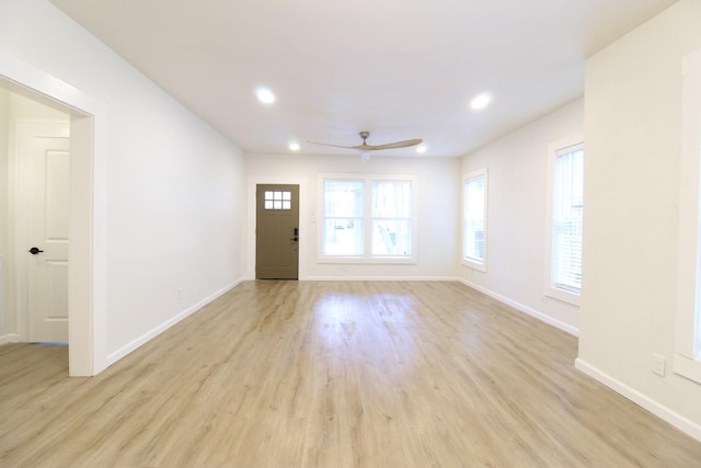 interior space featuring plenty of natural light, light wood-type flooring, and baseboards