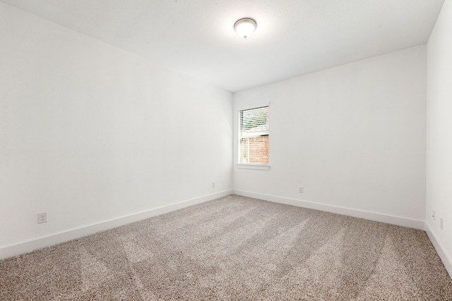 carpeted empty room with baseboards