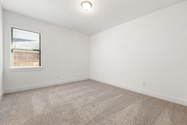 spare room featuring carpet floors and baseboards