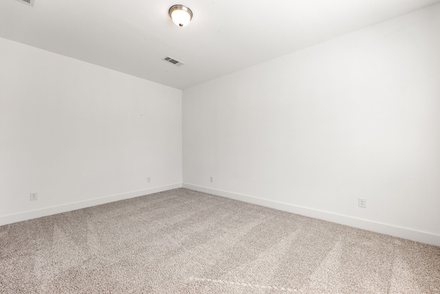 unfurnished room featuring carpet flooring, visible vents, and baseboards