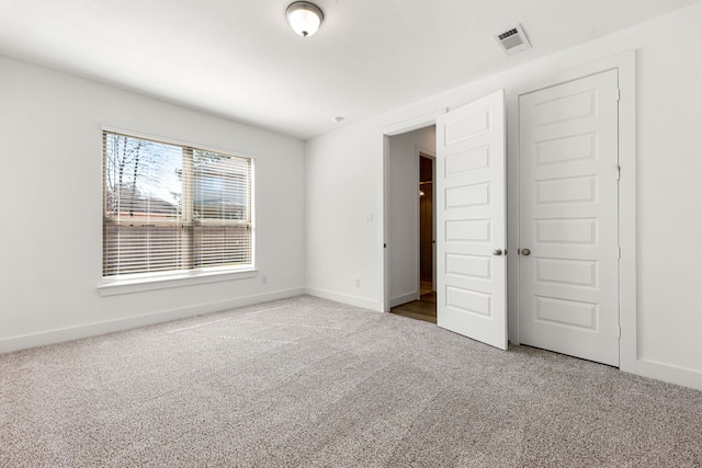 unfurnished bedroom with carpet, visible vents, and baseboards