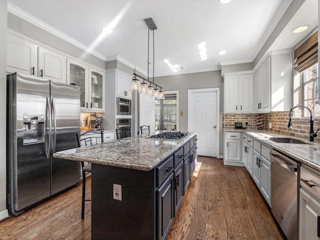 kitchen with stainless steel appliances, white cabinetry, and a kitchen island