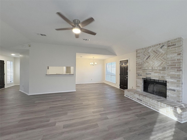 unfurnished living room featuring a brick fireplace, dark wood finished floors, and visible vents