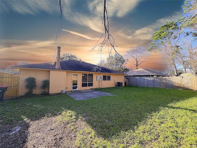 rear view of property featuring a patio area, a fenced backyard, a yard, and central air condition unit