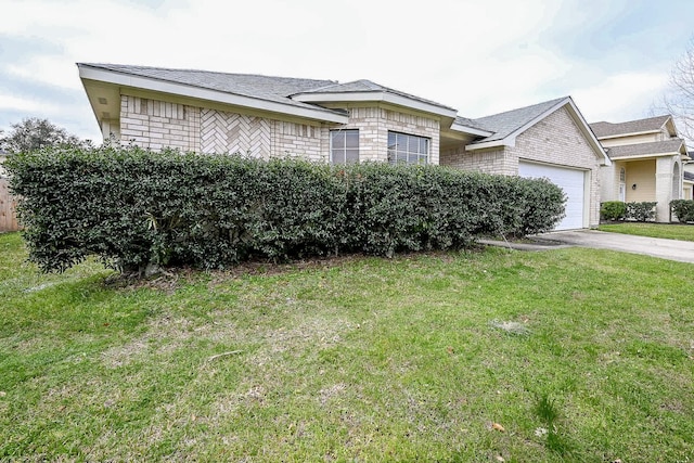 view of front of home featuring a garage, driveway, brick siding, and a front yard