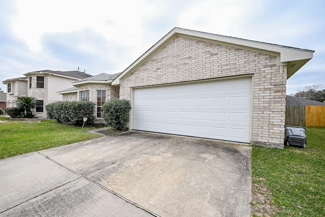 ranch-style house featuring brick siding, an attached garage, fence, driveway, and a front lawn