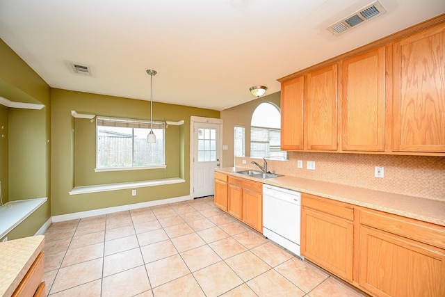 kitchen with a sink, visible vents, light countertops, dishwasher, and tasteful backsplash