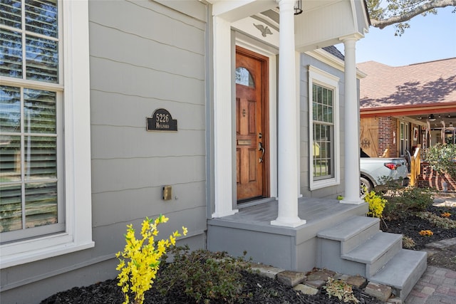 doorway to property with a shingled roof