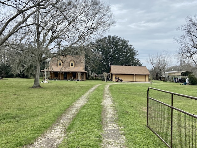 view of yard featuring a garage, driveway, and fence