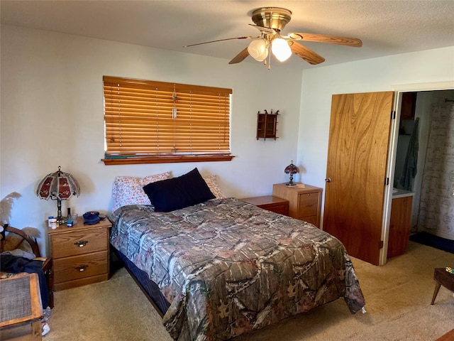 bedroom with light colored carpet, ceiling fan, and a textured ceiling