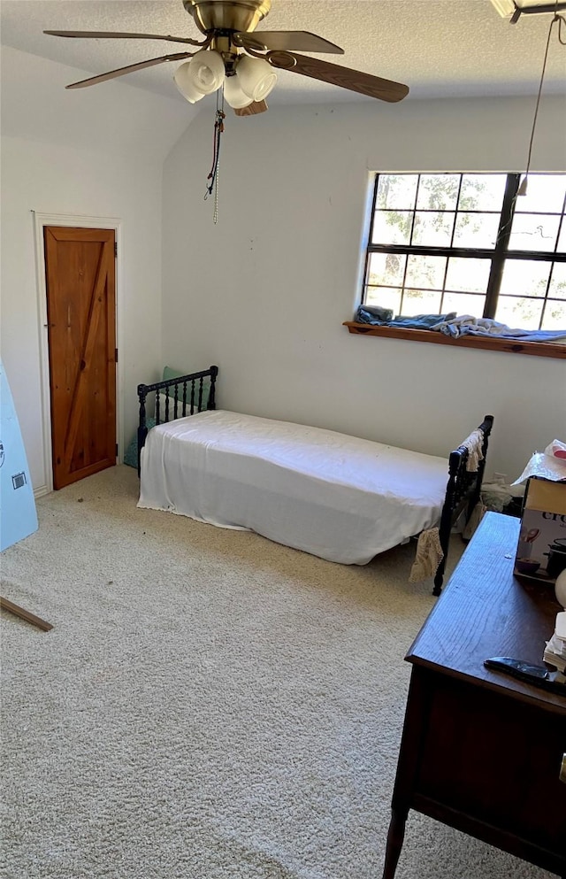 bedroom featuring a textured ceiling, carpet, and a ceiling fan