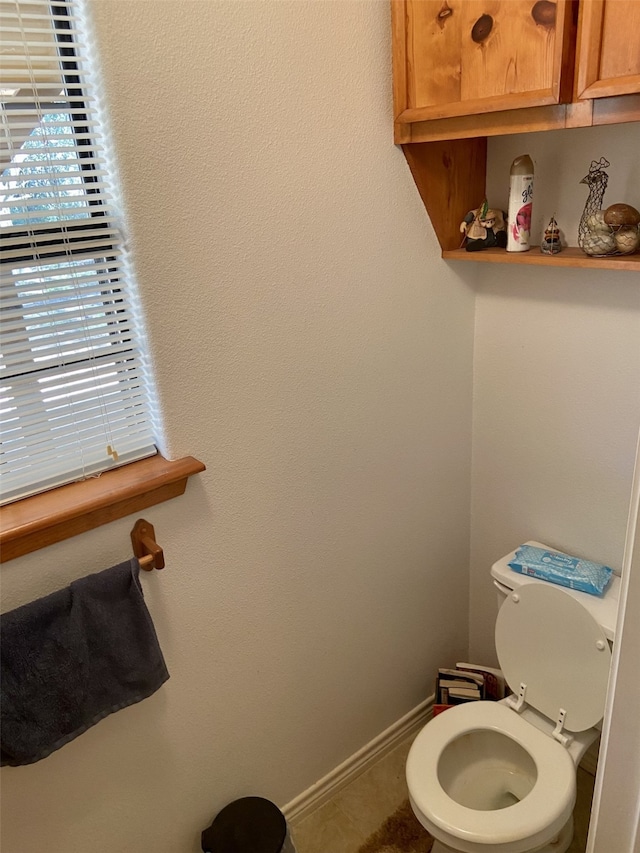 bathroom featuring toilet and baseboards