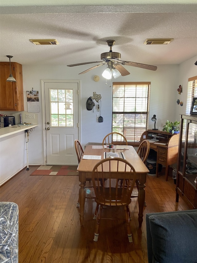 dining space featuring plenty of natural light, wood-type flooring, and visible vents