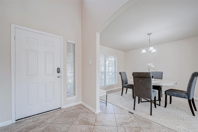 dining area with arched walkways, light tile patterned floors, baseboards, and a notable chandelier