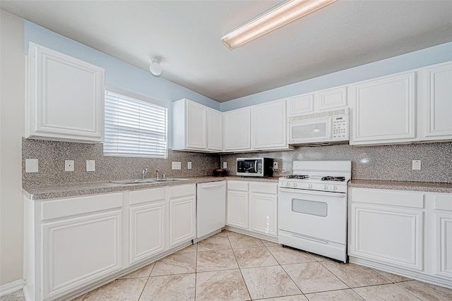 kitchen with light countertops, white appliances, white cabinets, and a sink