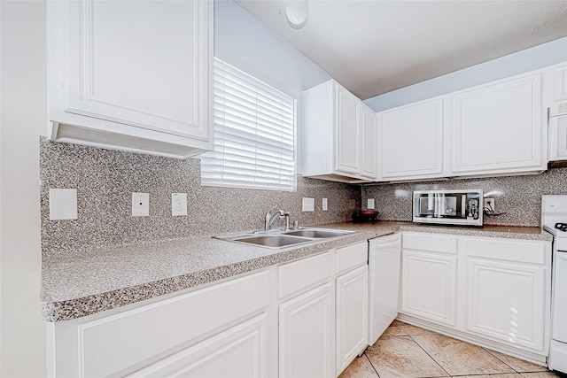 kitchen with white appliances, a sink, white cabinetry, light countertops, and decorative backsplash