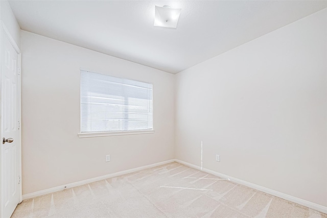 empty room with baseboards and light colored carpet